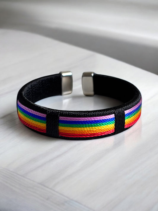Brazalete abierto con dijes y cuerdas de arcoíris