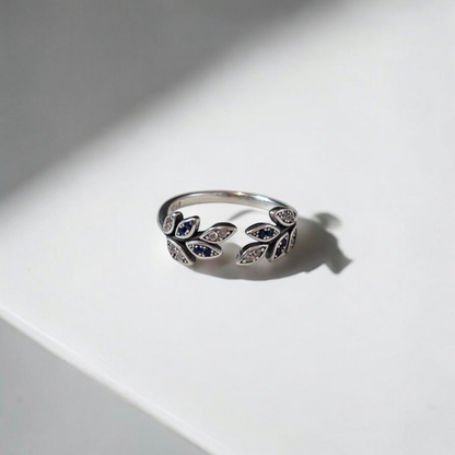 Omayra Boutique 925 sterling silver adjustable ring with a leaf design, blue and clear zircon stones on a white surface
