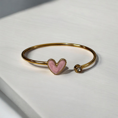 Omayra Boutique gold stainless steel cuff bracelet with a light pink heart charm and a single sparkling crystal gem.