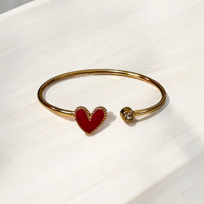 Omayra Boutique gold stainless steel cuff bracelet with a dark pink heart charm and a single sparkling gem accent.
