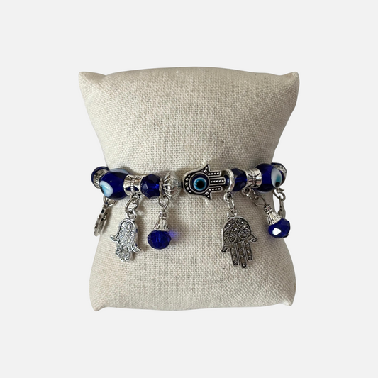 Omayra Boutique bohemian alloy and glass charm bracelet featuring blue evil eye beads and silver hamsa hand charms.