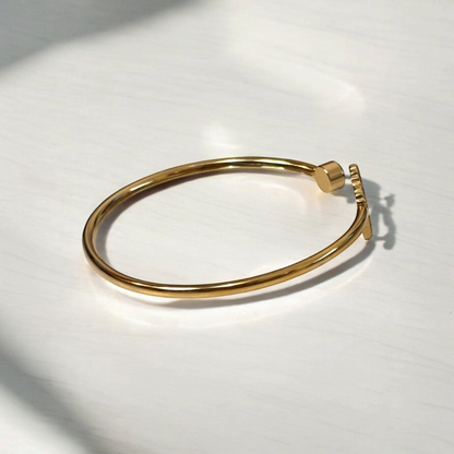 Omayra Boutique gold-tone stainless steel cuff bracelet with a heart charm and sparkling gem detail.