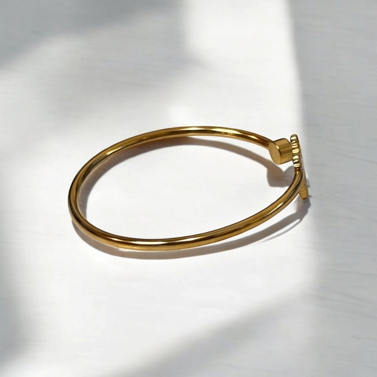 Omayra Boutique gold-tone stainless steel cuff bracelet with a heart charm and sparkling gem detail.