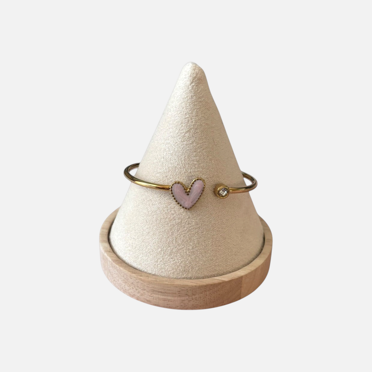 Omayra Boutique light pink heart cuff bracelet in stainless steel with a sparkling gem on a beige display cone