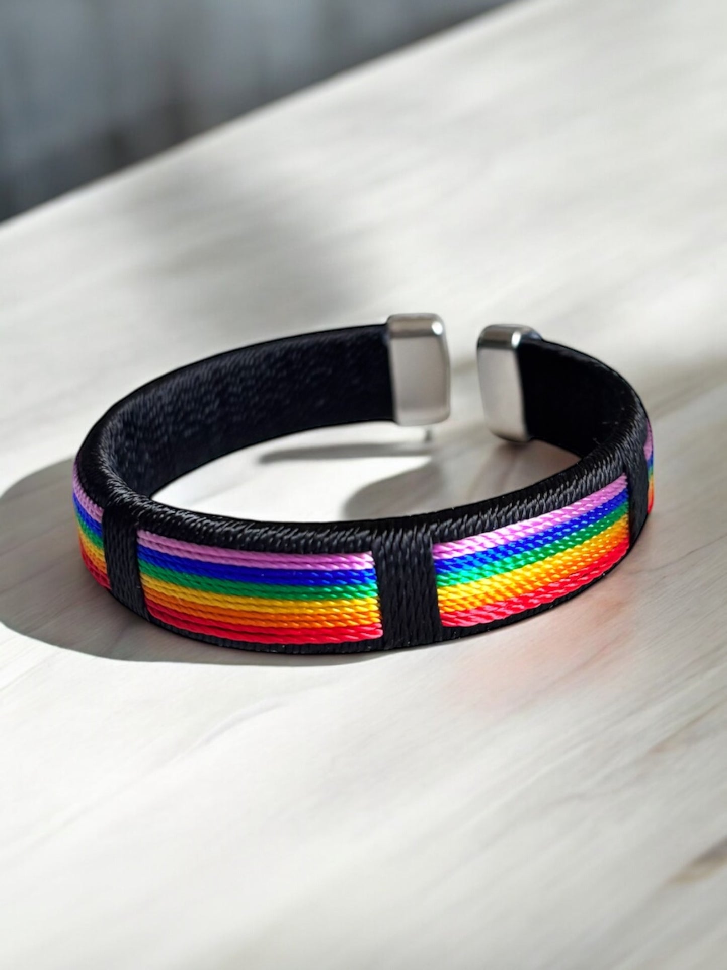 Brazalete abierto con dijes y cuerdas de arcoíris