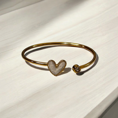Omayra Boutique gold stainless steel cuff bracelet featuring a white marbled heart and a sparkling crystal accent.