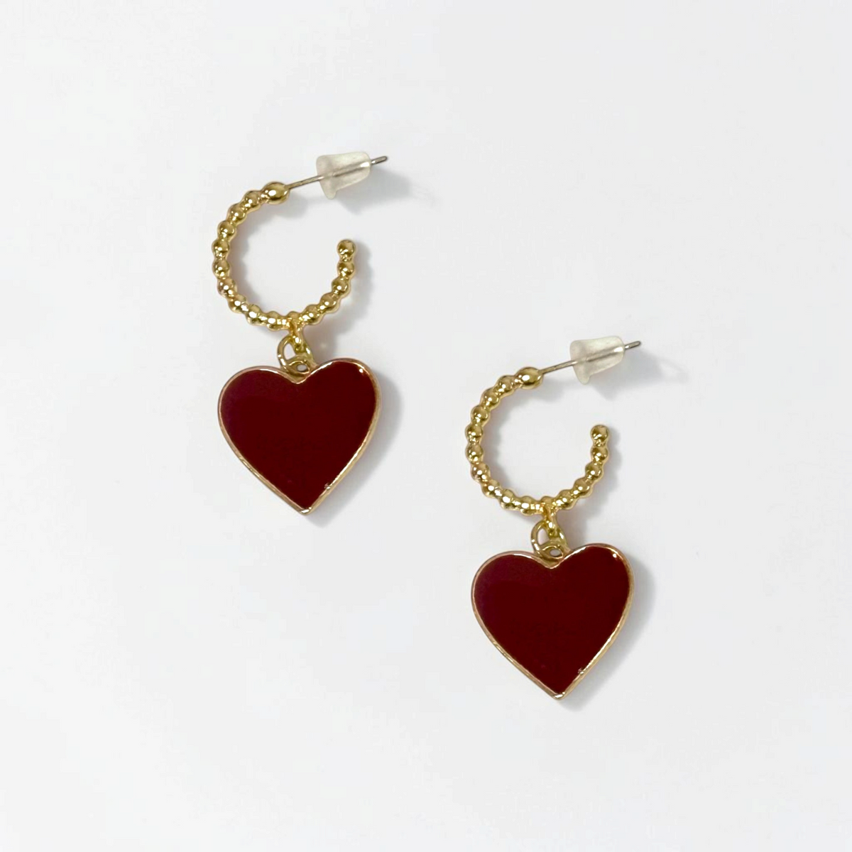 Omayra Boutique gold hoop earrings featuring a delicate burgundy heart charm, crafted from polished copper.