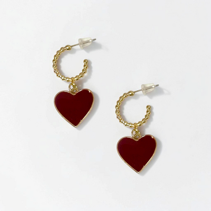 Omayra Boutique gold hoop earrings featuring a delicate burgundy heart charm, crafted from polished copper.