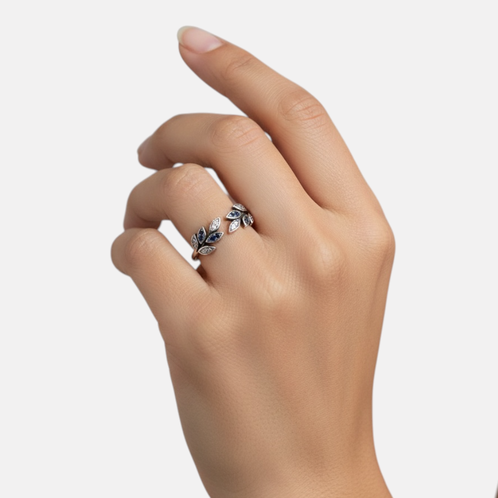 Omayra Boutique adjustable sterling silver ring with leaf design, blue and clear zircon stones on a woman's finger