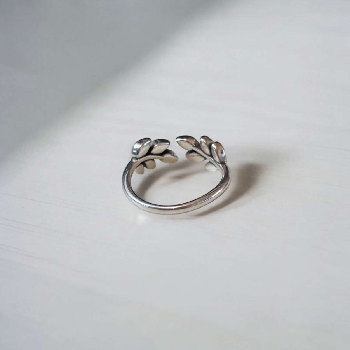Omayra Boutique 925 sterling silver adjustable ring with a delicate leaf design on a white surface.