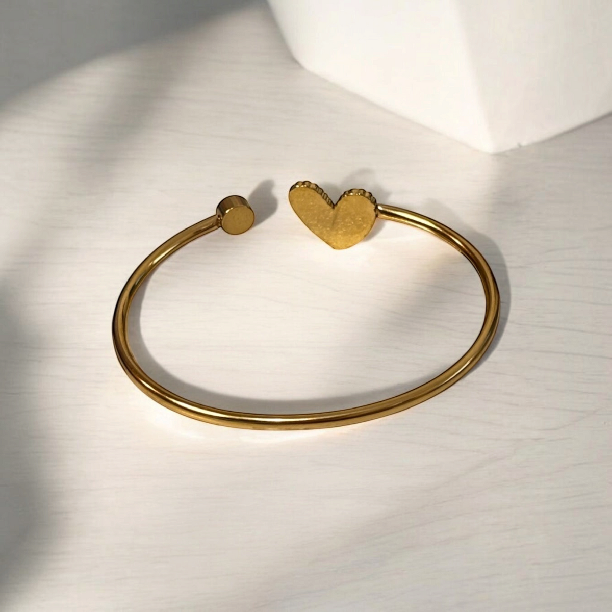 Omayra Boutique gold-tone stainless steel cuff bracelet with a heart charm and a small circular accent
