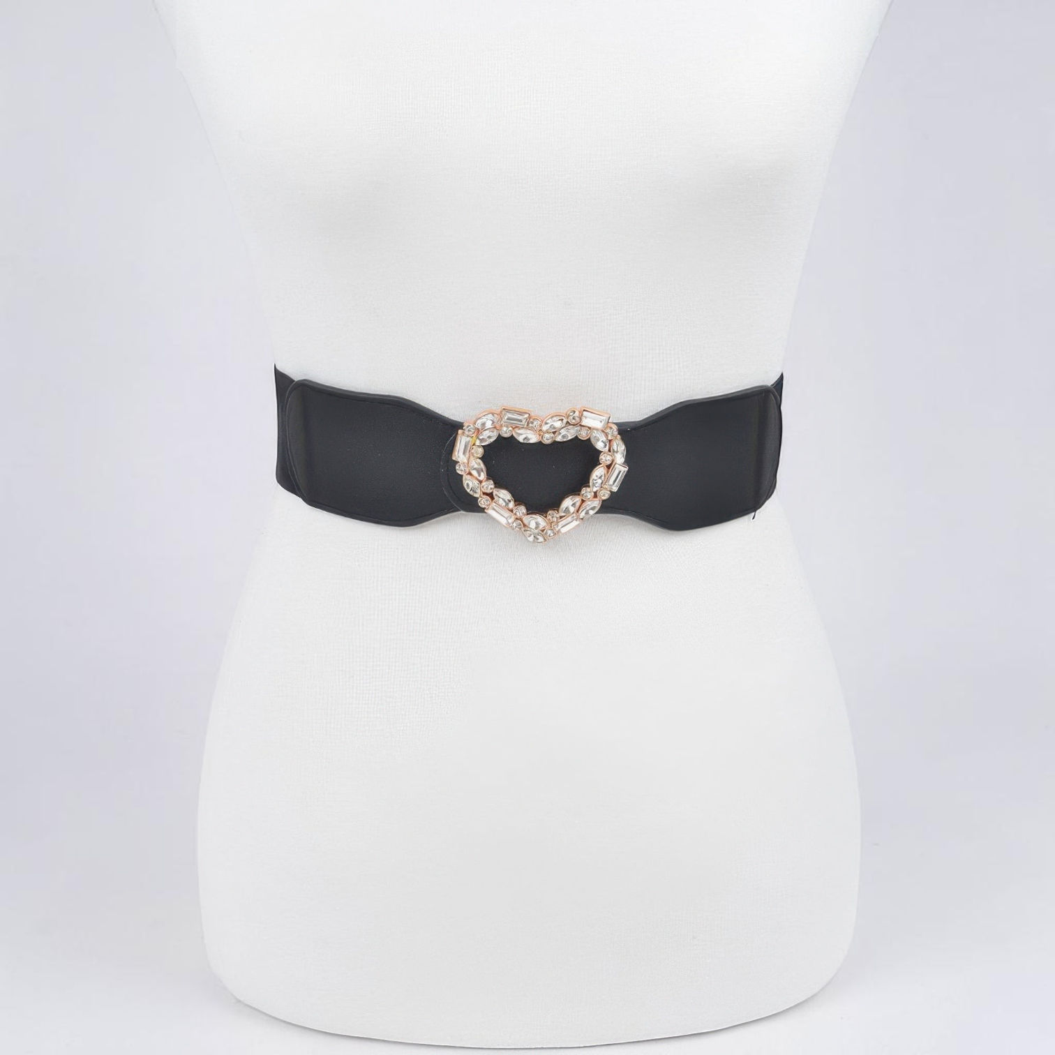 Omayra Boutique black elastic belt featuring a sparkling heart-shaped rhinestone buckle on a white mannequin torso.