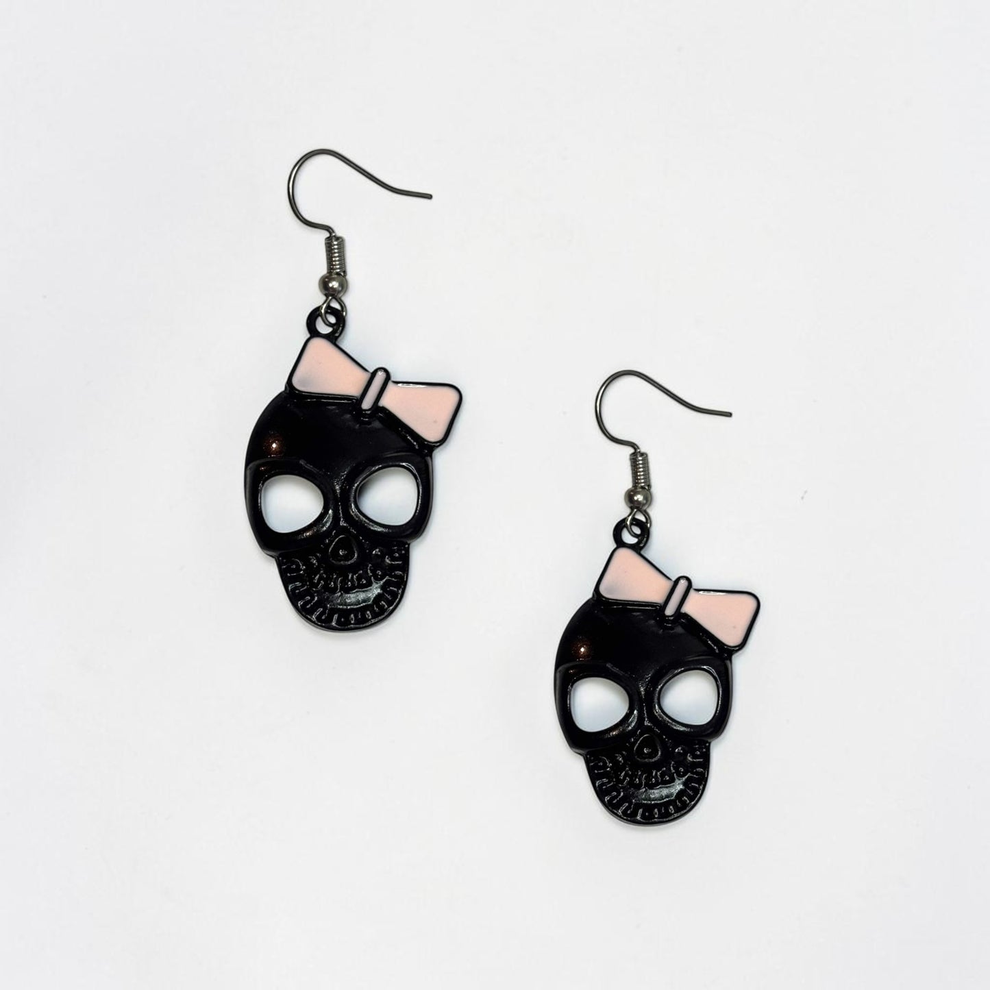 Omayra Boutique black skull earrings with pink bows, 2-inch alloy dangle earrings with a cute and spooky design.
