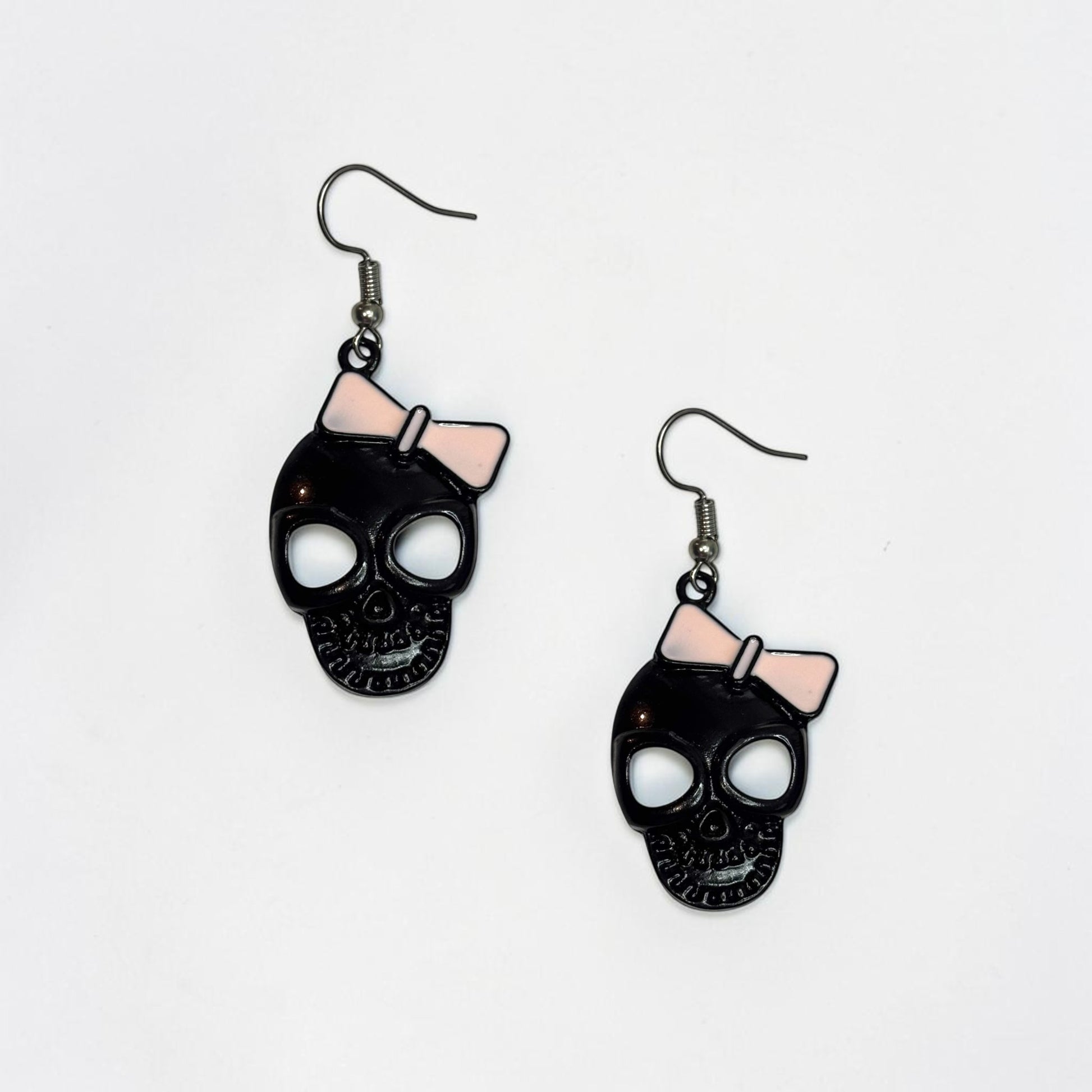 Omayra Boutique black skull earrings with pink bows, 2-inch alloy dangle earrings with a cute and spooky design.