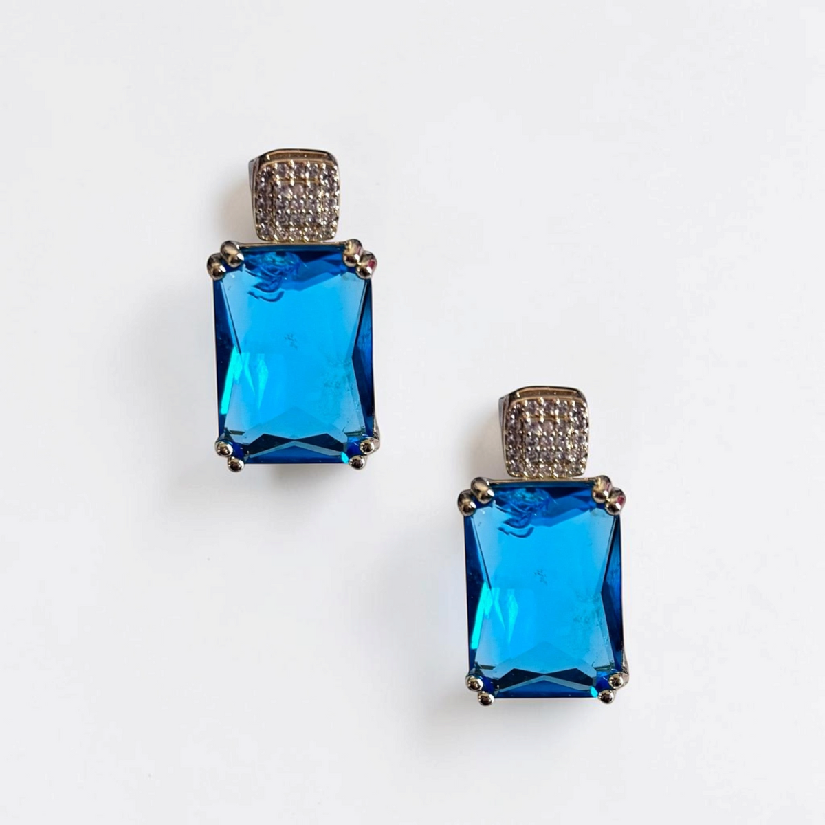 Omayra Boutique Blue Princess Drop Earrings with blue cubic zirconia and light gold setting. Classic 1 inch drop earrings.