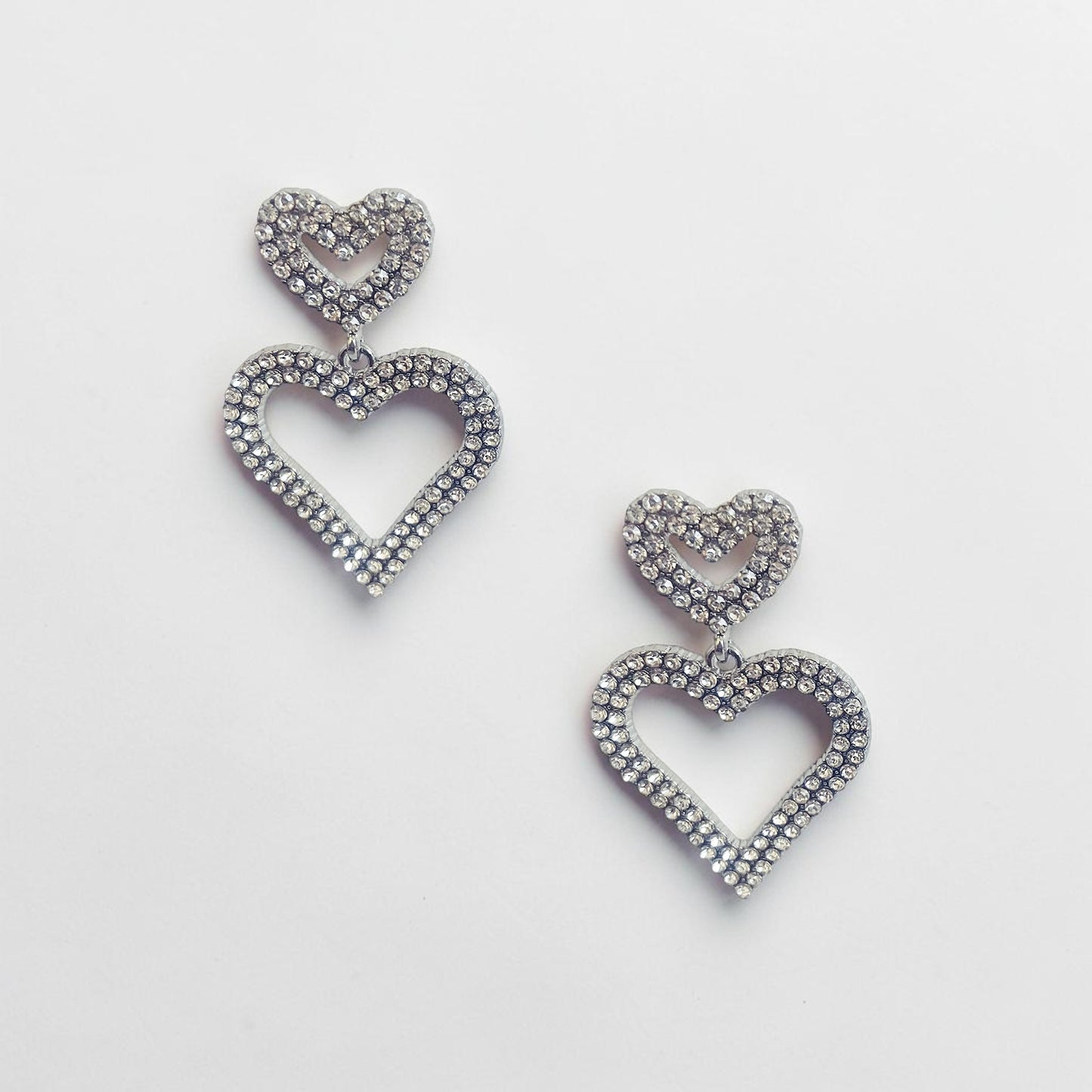 Omayra Boutique double heart drop earrings in silver-tone zinc alloy with sparkling crystal stones.