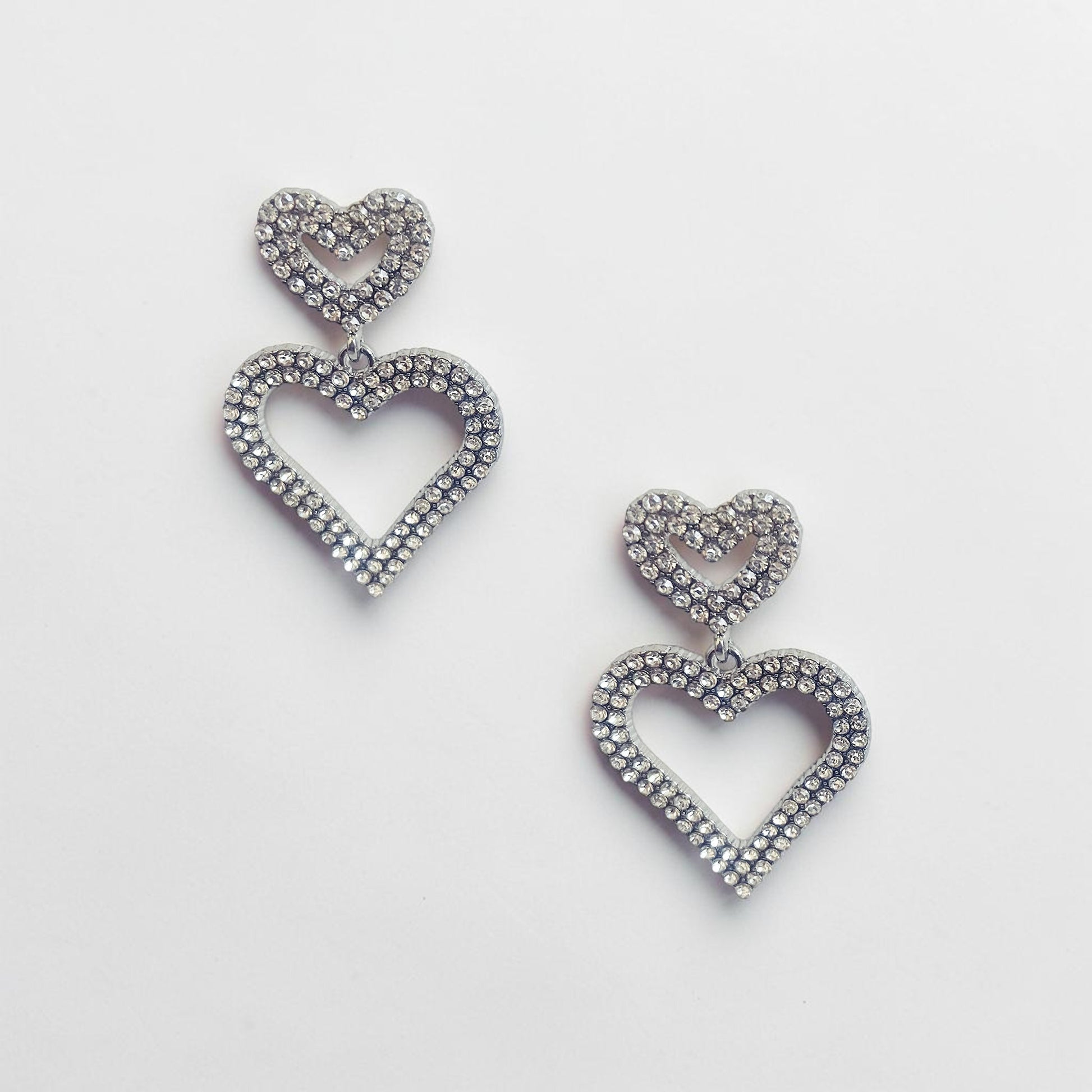 Omayra Boutique double heart drop earrings in silver-tone zinc alloy with sparkling crystal stones.