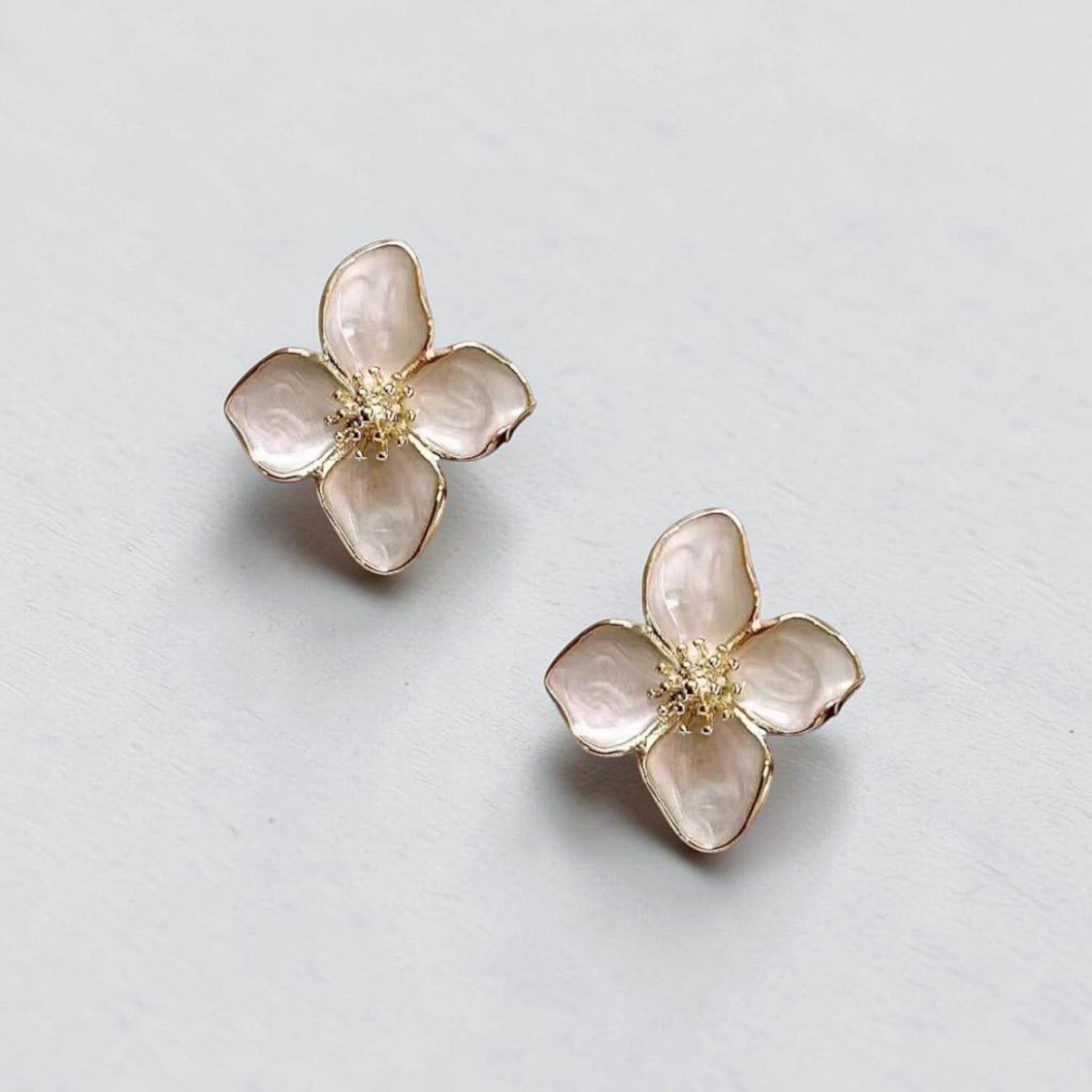 Omayra Boutique flower stud earrings in light pink enamel with gold-tone centers, crafted from zinc and copper alloy.