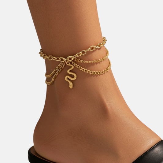 Omayra Boutique gold multilayer ankle bracelet with a delicate snake pendant worn on a woman's ankle
