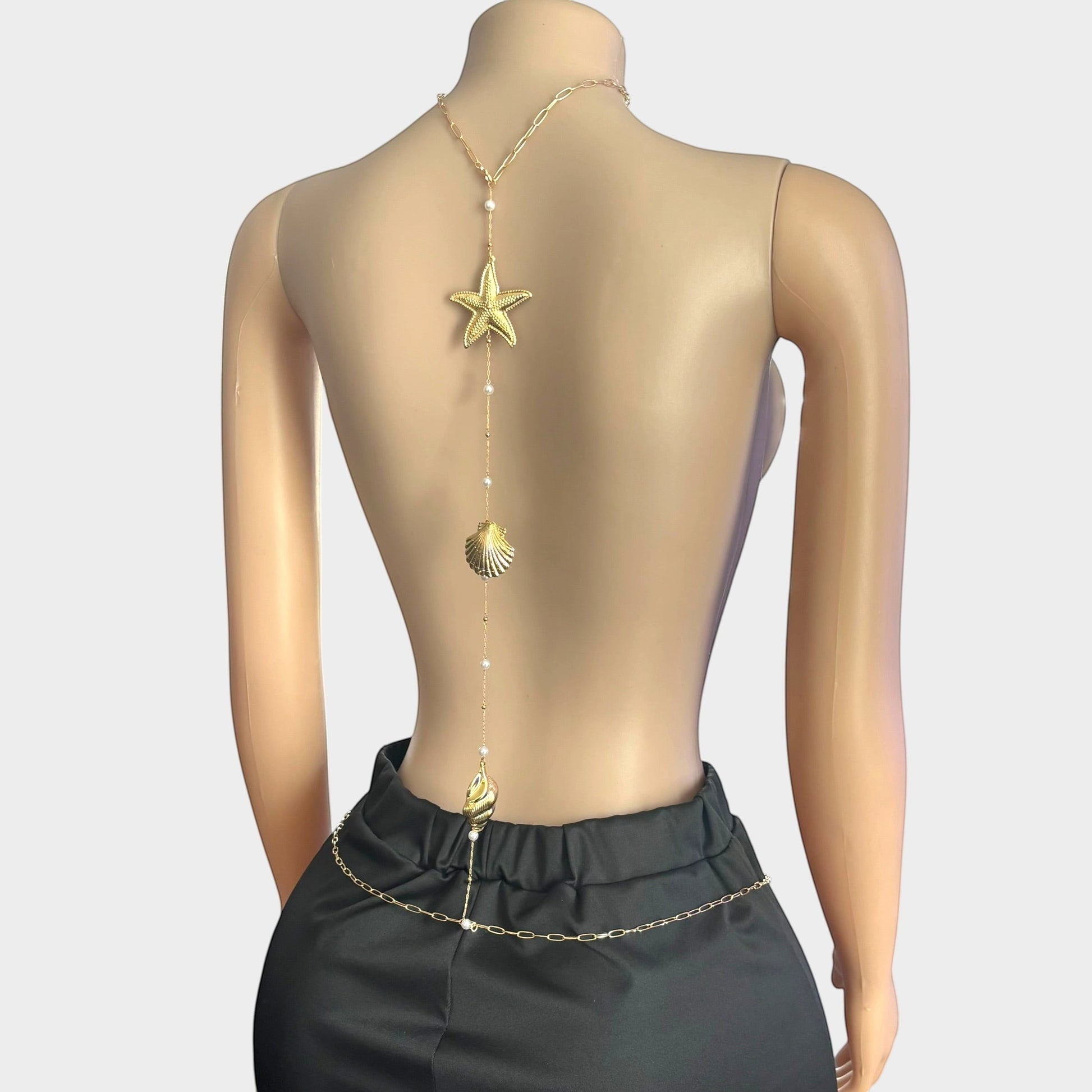 Omayra Boutique gold-tone back body chain featuring starfish and seashell charms with faux pearl accents on a mannequin