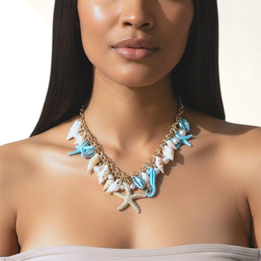 Omayra Boutique multi-charm necklace featuring starfish, seahorse, and seashell charms with pearl accents on a model.