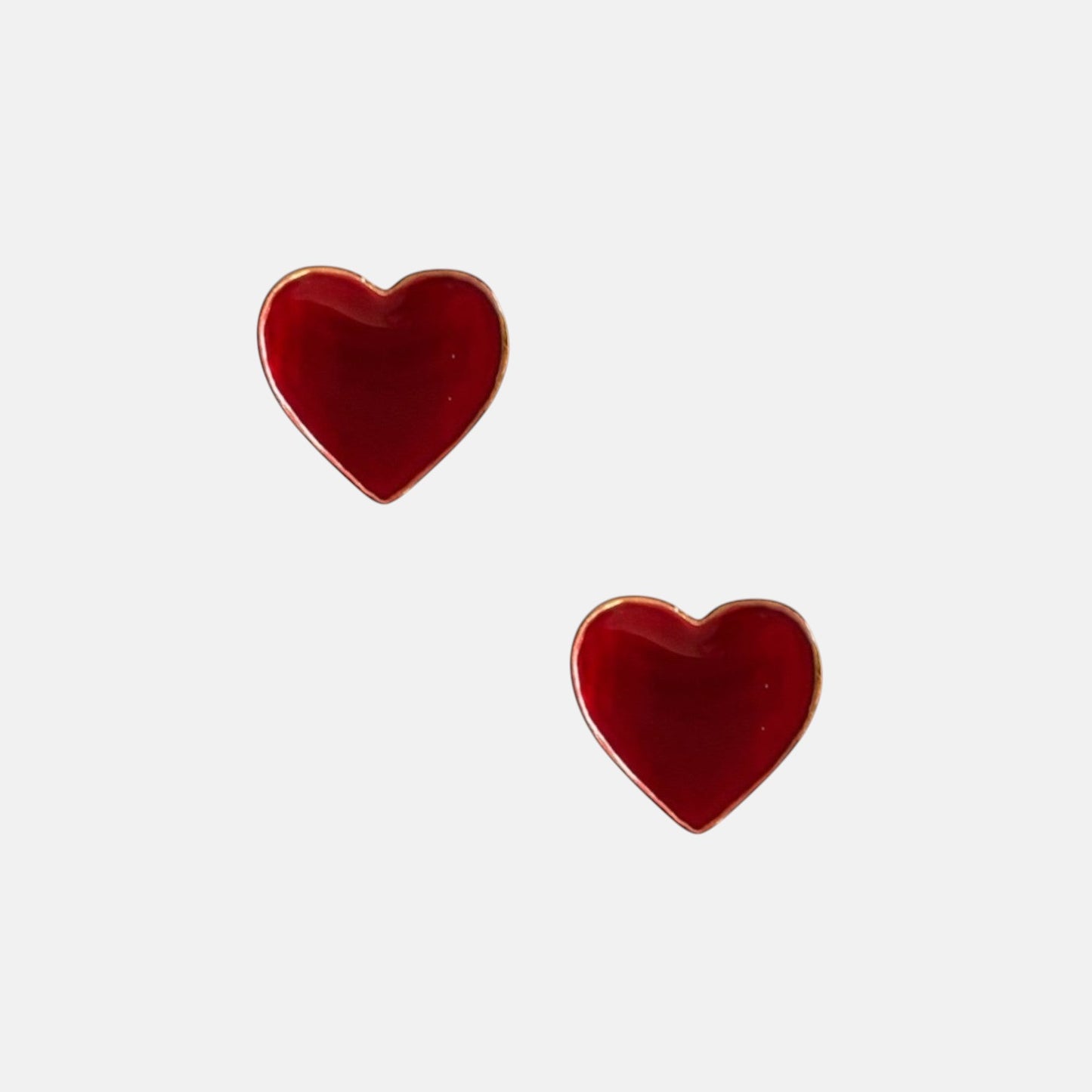 Omayra Boutique wine red heart-shaped stud earrings with gold trim made of zinc alloy on a white background.