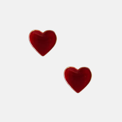 Omayra Boutique wine red heart-shaped stud earrings with gold trim made of zinc alloy on a white background.