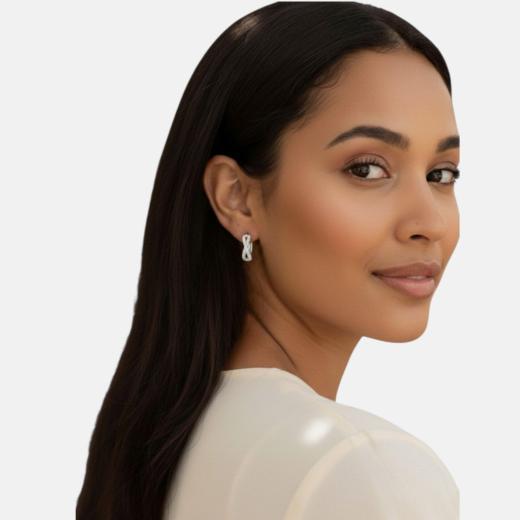 Omayra Boutique small silver hoop earrings with zircon stones, worn by a woman with long dark hair.